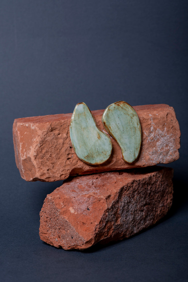 Orecchini Isola in ceramica, design ispirato alla natura, forme sinuose, sfumature verdi e marroni, finitura lucida.