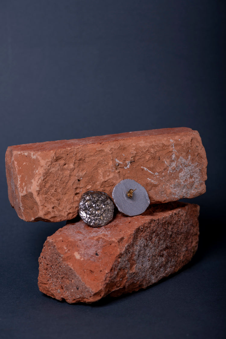 Orecchini Magma in ceramica fatti a mano con texture naturale e dettagli tridimensionali. Design geometrico e audace, perfetti per uno stile sofisticato senza eccessi.