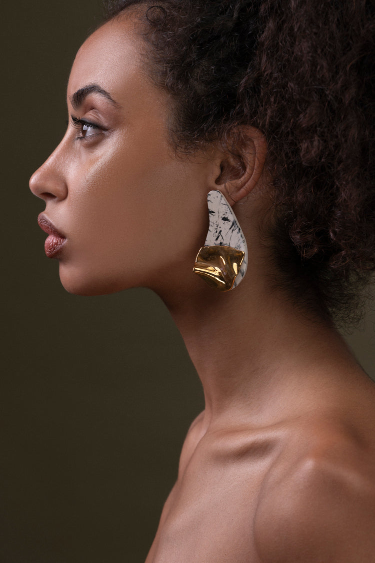 Orecchini Volcano in ceramica, smaltati in oro e platino, design ispirato alla potenza vulcanica, struttura organica con base geometrica.